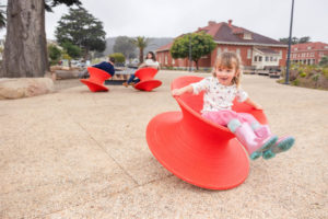 little girl playing in a red spin wheel at presidio tunnel tops