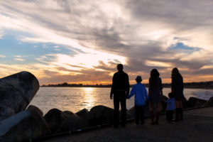family looking over santa cruz ocean for silhouette photography during sunset