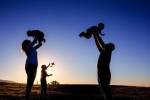 family of five silhouette photograph with a kid playing with an airplane