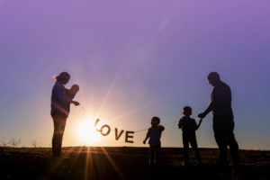 family of five holding a love sign for silhouette photograph