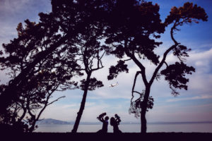 family of four silhouette photography with a plane landing in the background