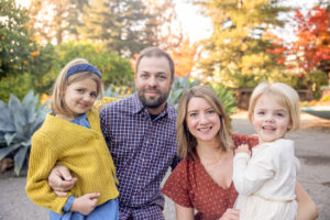family of four portrait with fall colors behind them