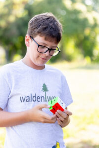 tween boy putting together a rubik's cube for his elementary promotion photo session