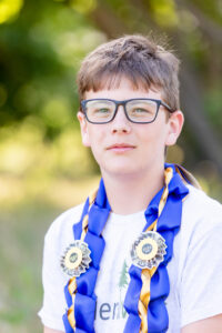tween boy wearing a money lei for his elementary promotion photo session