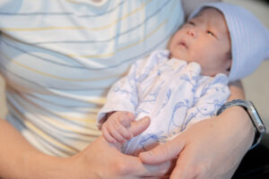 newborn baby holding mom's thumb