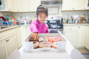 toddler picking out donut to have during her newborn photo session