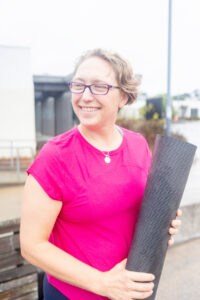 personal trainer holding a yoga mat and looking off camera for her business branding photos in san francisco