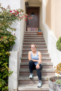 woman sitting on the front steps of her house about to workout
