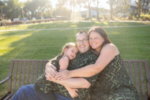 family of three sitting on the bench at charleston park in mountain view