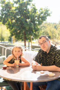 dad and daughter making faces at outdoor patio table