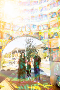 family of three standing under artwork at google visitors center