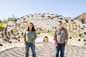 family of three under artwork at google visitors center