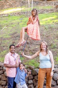 family of four for backyard family photos with a girl on a zip line