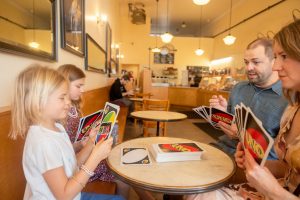 family of four playing uno in a cafe