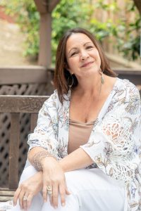 woman sitting on a wooden bench for a headshot